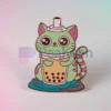 Una spilla personalizzata con un gatto che tiene gioiosamente in mano una bevanda a base di bubble tea, perfetta per gli amanti dei gatti e del boba tea.