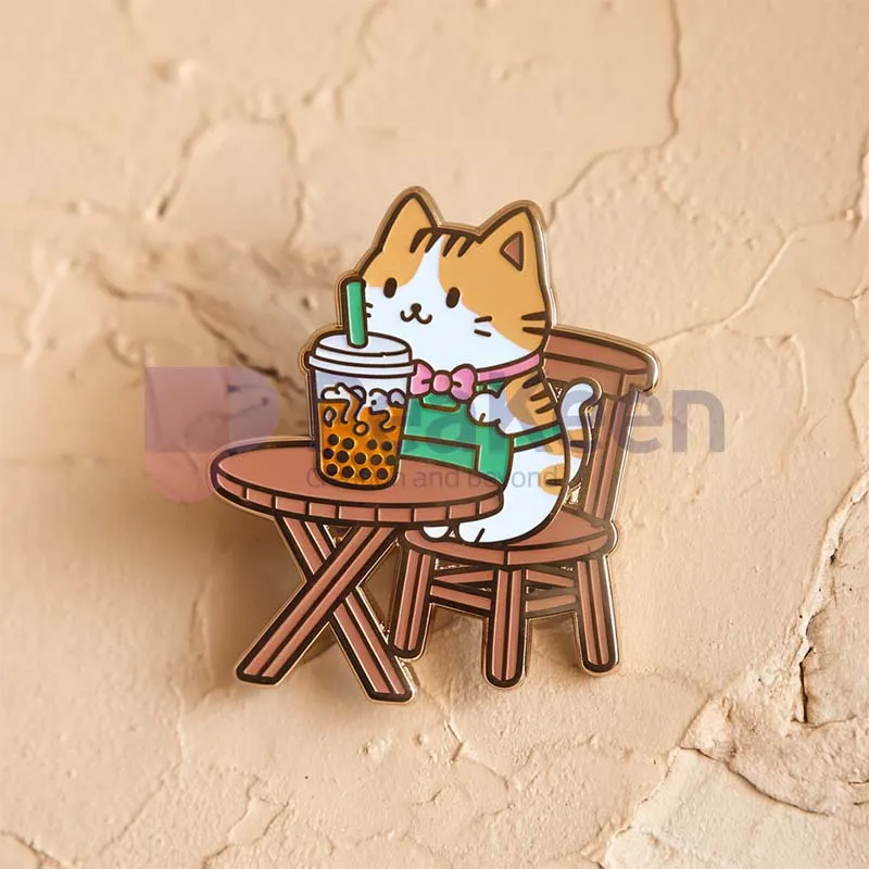 A cute pin featuring a cat sitting at a table with a cup of tea, designed as a custom boba cat pin.