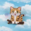 Un gatto appollaiato su un ramo contro un cielo azzurro, che mette in mostra il suo design giocoso e stravagante.