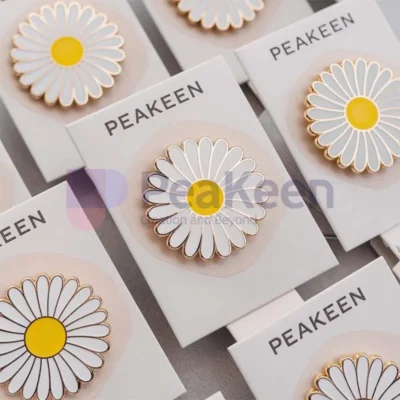 Custom white and yellow daisy pin displayed on a card, showcasing its vibrant colors and intricate design.