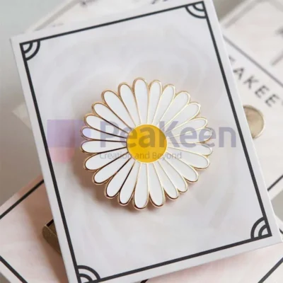 Custom white and yellow daisy pin displayed on a card, showcasing its vibrant colors and intricate design.