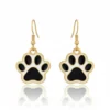 Gold-plated earrings featuring a black and white dog paw design, perfect for dog lovers.