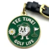 Golf ball charm with a black and gold buckle, designed for golf bag tags.