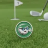 A golf ball wearing sunglasses next to a golf club on the green, serving as a playful golf ball marker.