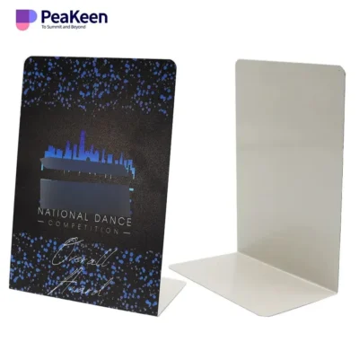 A white and blue card featuring the National Dance Association logo, alongside metal competition tin signs.