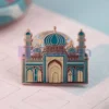 Épingle en émail coloré représentant une mosquée, symbole de la foi et de la culture. Idéal pour un usage personnel ou un cadeau. Épingle à mosquée personnalisée.