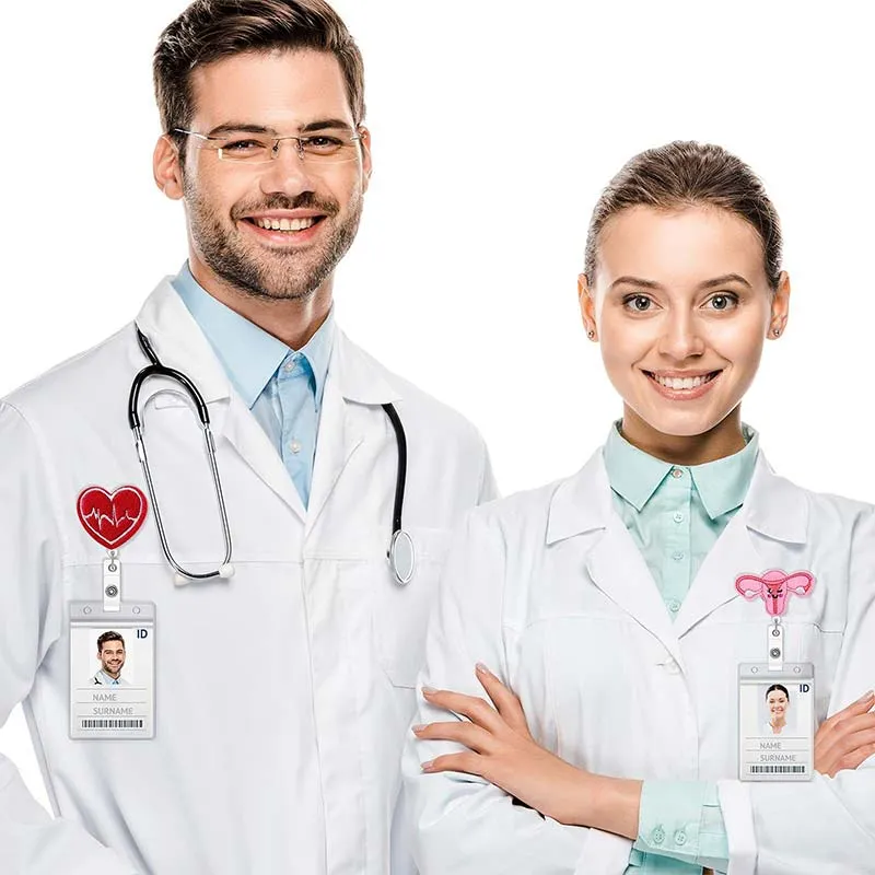 A man and woman in lab coats stand side by side, showcasing their nurse badge reels with professionalism and teamwork.