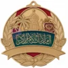Una medaglia d'oro personalizzata con il nome "Arabia Saudita" ben visibile sulla superficie.