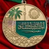 Medaglia personalizzata con il nome "Arabia Saudita" ben visibile sulla superficie.