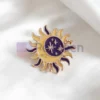 Pin de esmalte personalizado con un diseño de sol y luna morados sobre un fondo blanco limpio.