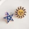 Dos pins de esmalte personalizados con un sol y una estrella, que lucen colores vibrantes y diseños intrincados.