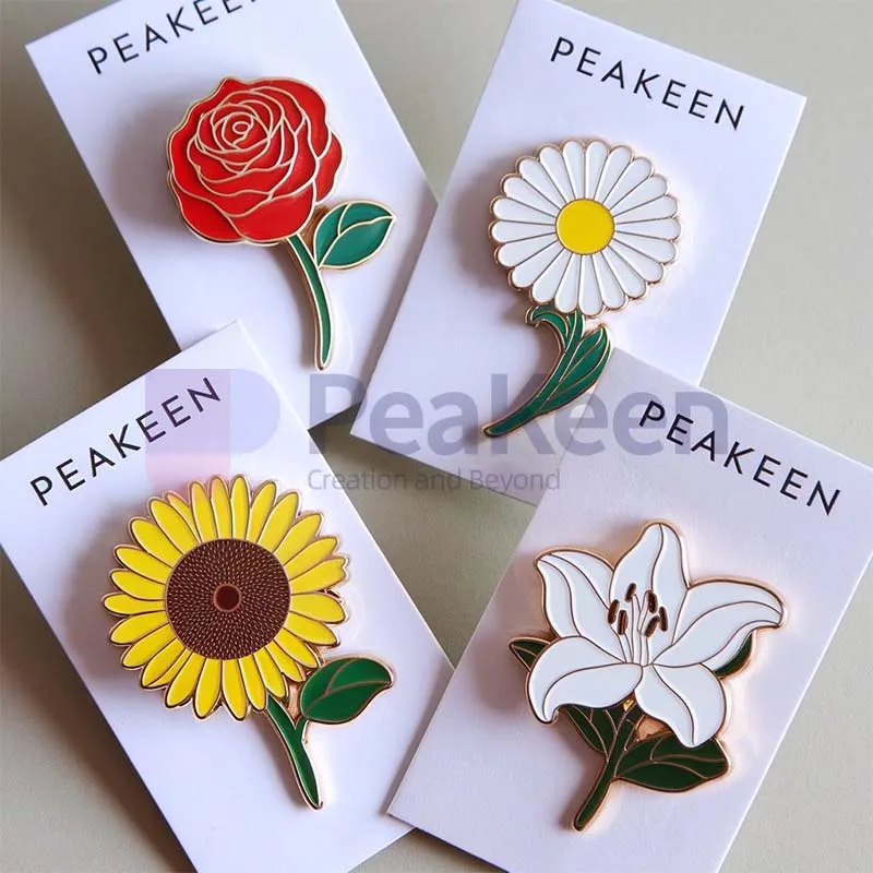 An image showcasing four beautifully crafted soft enamel flower pins: a vibrant red rose, a delicate white daisy with a yellow center, a bright yellow sunflower with a rich brown center, and an elegant white lily. Each pin is mounted on its own sleek paper card, with the brand name 'PeaKeen' prominently printed at the top. The combination of vivid colors and glossy enamel finish highlights the intricate details of each flower, while the uniform presentation on branded cards adds a professional and cohesive touch. Perfect for gifting or retail display.