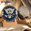 На видном месте выставлена монета с изображением морских котиков США, демонстрирующая ее замысловатый дизайн и значение в военных традициях.