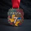Colorful medal for the 7th annual fiesta, featuring festive designs and the event's name prominently displayed.