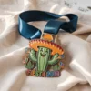 Fiesta 2019 medal featuring a decorative cactus design, celebrating the annual cultural festival.
