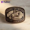 Una hebilla de cinturón con la inscripción "Campeón de Rodeo" bien visible en su superficie.