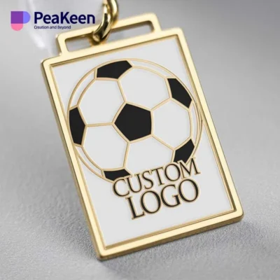 A gold keychain featuring a soccer ball design, accompanied by a soccer medal, symbolizing sports achievement.