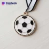 Eine Fußballmedaille mit einer schwarz-weißen Schleife, die die Leistung im Fußballsport symbolisiert.