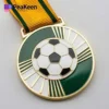 Eine goldene Fußballmedaille mit einem detailliert gestalteten Fußball, der für herausragende Leistungen in diesem Sport steht.