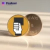 A pin featuring a hand holding a card labeled "Heads" and "Tails," symbolizing soccer referee coin toss decisions.