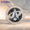 Star Trek badge displayed on a clear surface, accompanied by a Space Force challenge coin for a unique collectible look.