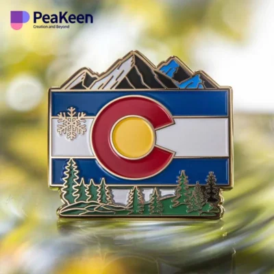 Colorado flag pin featuring mountains and trees, symbolizing the state's natural beauty and pride.