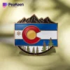 A pin showcasing the Colorado flag set against a mountain landscape.