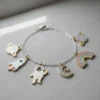 A colorful bracelet featuring an enamel space-themed charm and a vibrant rainbow design.