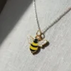 Bee necklace featuring a yellow and black enamel charm of a bee, showcasing intricate details and vibrant colors.