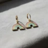 Two rainbow enamel earrings showcased on a white surface, highlighting their bright colors.