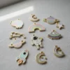 A collection of colorful space-themed enamel charms displayed on a table.