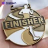 A person proudly displays a gold finisher medal, showcasing their achievement in a competitive event.