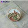 A hiking pin featuring a scenic mountain landscape, perfect for outdoor enthusiasts and collectors.
