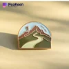 A hiking pin featuring a scenic mountain landscape, perfect for outdoor enthusiasts and collectors.