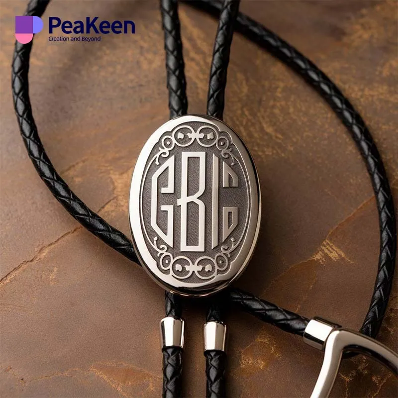 Collier monogrammé en argent avec un cordon en cuir stylisé, conçu comme un accessoire de cravate bolo unique.