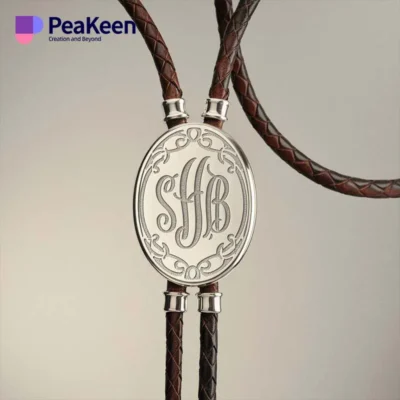 A leather lariat bolo tie featuring a personalized monogrammed name, showcasing elegance and style.