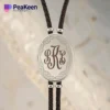 Silver and black leather bracelet featuring a monogrammed initial, styled like a bolo tie for a unique accessory.