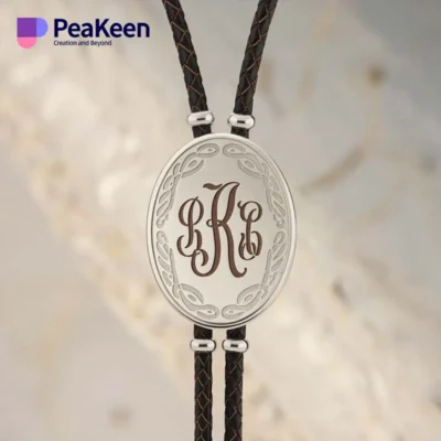 Silver and black leather bracelet featuring a monogrammed initial, styled like a bolo tie for a unique accessory.