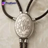 Elegant silver monogrammed necklace on a leather cord, designed as a bolo tie for a stylish touch.