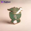Un pin's de pharmacie vert et or avec un symbole médical proéminent, représentant les soins de santé et le professionnalisme.