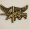 Gold SWAT badge featuring a gun and an eagle emblem, symbolizing law enforcement authority and strength.