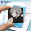 An individual holds a vibrant pin adorned with an anime character, highlighting their passion for anime merchandise.