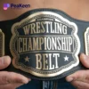 A man proudly displays a wrestling championship belt, showcasing his achievement in the sport.