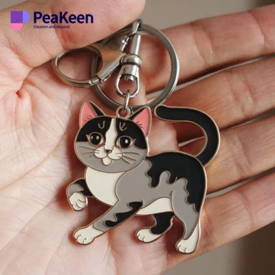 A hand displays a metal keychain shaped like a cat, emphasizing a fun and whimsical touch to everyday items.