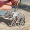 Close-up of a hand grasping a metal elephant keychain, showcasing its intricate details.