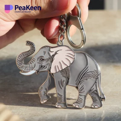 A person holds a metal keychain featuring a detailed elephant design, showcasing a unique accessory.