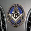 A Masonic emblem showcased on the front of a car, highlighting its connection to the Freemason community.