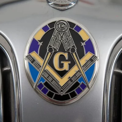 A close-up of a car's front featuring a prominent Masonic emblem, symbolizing fraternity and tradition.