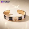 Gold-plated cuff bracelet with soft enamel, showcasing a sleek and elegant design perfect for any occasion.