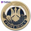 Gold and blue Navy SEAL badge displayed on a challenge coin, symbolizing elite military service and honor.